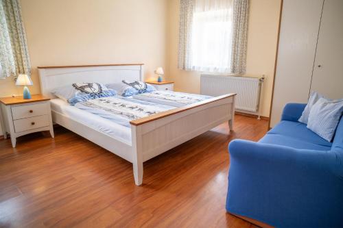 a bedroom with a bed and a blue couch at Stadlerhof Alpen- & Seeblick in Kirchanschöring