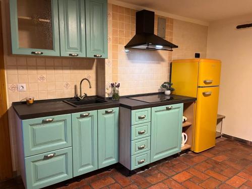 a kitchen with green cabinets and a yellow refrigerator at Apartment Abinkar in Tolmin