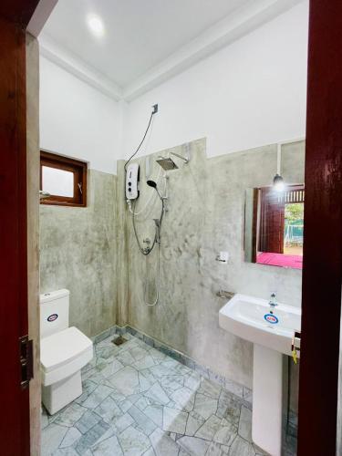 a bathroom with a toilet and a sink at Bentota Upali Villa in Bentota