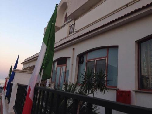 a building with a flag in front of it at Hotel Lungomare Brancaleone in Brancaleone Marina