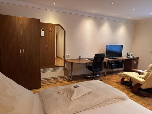 a bedroom with a bed and a desk with a computer at Engelhard Das Landhotel Garni in Kirchheim am Ries