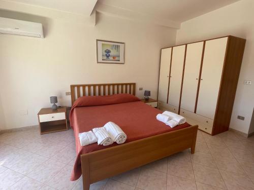 a bedroom with a bed with two towels on it at Hotel Lungomare Brancaleone in Brancaleone Marina