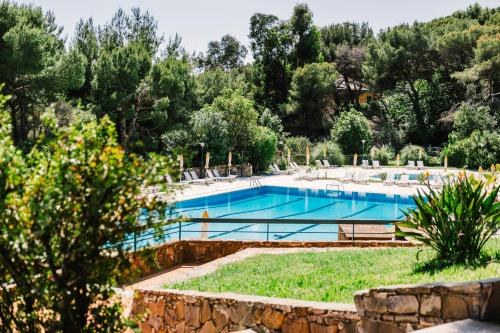 a large swimming pool with chairs and trees at SPORTING PINAMARE in Marina di Andora