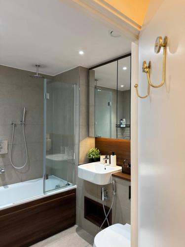 a bathroom with a sink and a shower and a toilet at Renovated Charm - London Hideaway in London
