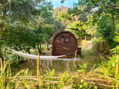 a hammock in front of a small shack at Quinta dos Covões in Fornos de Algodres