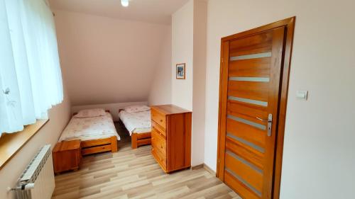 a small bedroom with a bed and a wooden door at Domek Wichrowy groń in Korbielów