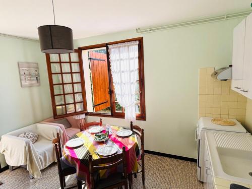 une salle à manger avec une table et une cuisine dans l'établissement Appartement T2 Est à 300m des plages, à Mimizan