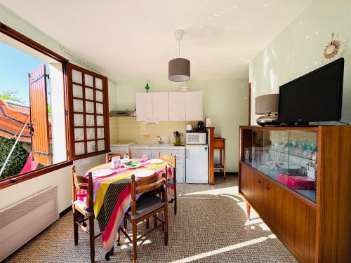 une cuisine avec une table à manger et une télévision dans l'établissement Appartement T2 Est à 300m des plages, à Mimizan