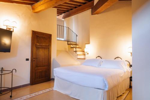 a bedroom with a white bed in a room at Rocca d'Orcia Suites and Villas in Castiglione dʼOrcia