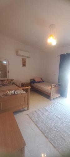 a small room with two beds and a table at Diana Beach Villa spacious detached فيلا واسعه مستقله ديانا ONLY FAMILIES بيتش in Dawwār al Ḩajj Aḩmad