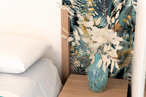 a blue vase sitting on a table next to a bed at Vico degli Orti in Mistretta