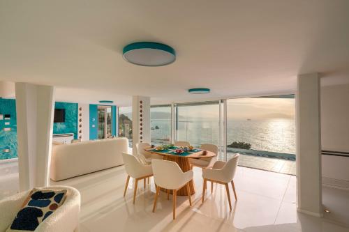 a dining room with a table and chairs and the ocean at Laguna Blu - Resort Villa overlooking the sea on the Amalfi Coast in Vietri sul Mare