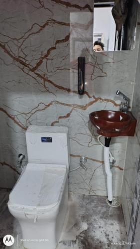 a bathroom with a toilet and a sink at hotel Neelgiri in Kichha