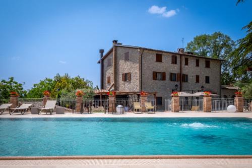 un edificio con piscina en frente de un edificio en Agriturismo Beata Vanna, en Fabro