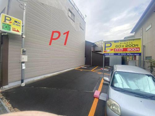a parking lot with a car parked next to a garage at 橘の郷 ORANGE inn Tengachaya in Osaka