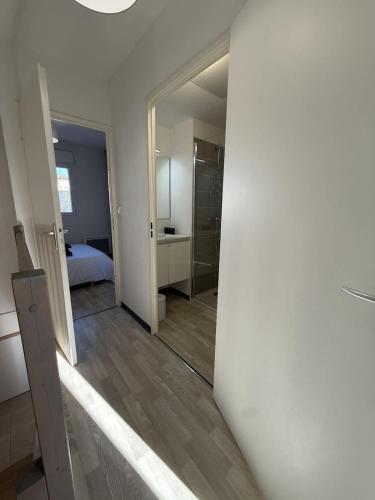 - un couloir d'une chambre avec un lit et un miroir dans l'établissement Valras-Loc La Dune - Evasion Cotiere Havre de Paix, à Sérignan