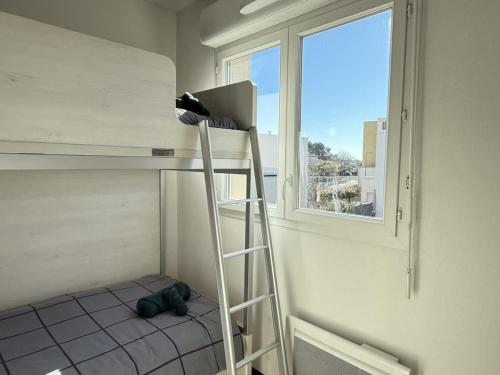 - un lit superposé avec une échelle dans une chambre avec une fenêtre dans l'établissement Valras-Loc La Dune - Evasion Cotiere Havre de Paix, à Sérignan