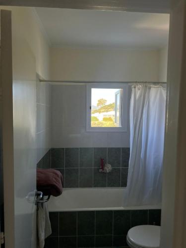 a bathroom with a shower and a toilet and a window at Poolside Escape - Polis in Polis Chrysochous