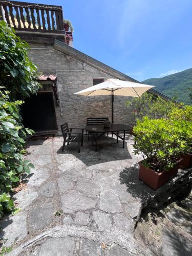 a patio with a table and an umbrella at La casa di Martina in Castelpizzuto