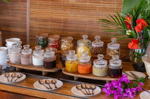 a table with jars of jam and plates of food at Cocotiers Hotel – Mauritius in Port Louis