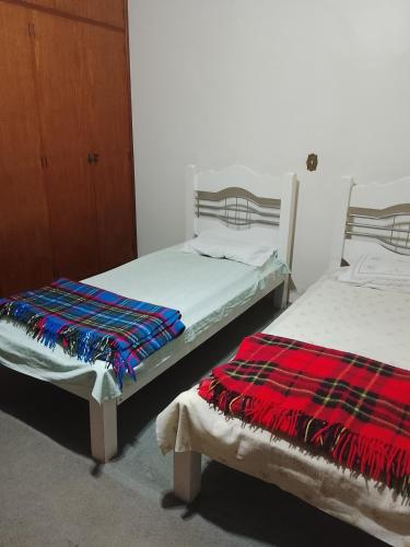 Dos camas una al lado de la otra en una habitación. en Recanto dos Amigos, en Tietê