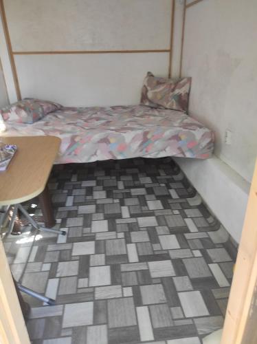 a small room with a bed and a table at Pensiunea agroturistica Casa Sirca in Boghiş