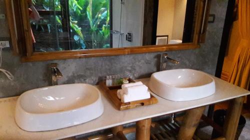 a bathroom with two sinks and a mirror at Namkat Yorla Pa Resort in Ban Kat