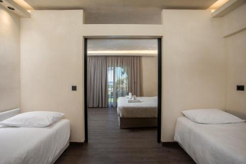 a hotel room with two beds and a mirror at Aiora Resort in Pefki Rhodes