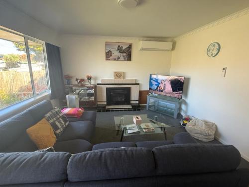 a living room with a couch and a tv at 3 Bedroom Home by the Reserve in Rotorua