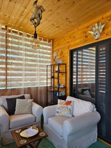 a living room with two couches and a table at Бунгало HAKUNA MATATA, Къмпинг Созопол Еко, плаж Градина in Sozopol