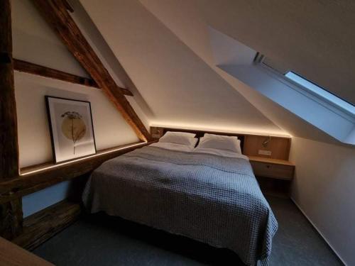 a bedroom with a large bed in a attic at Apartmán Na Břehu in Luhačovice