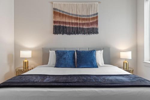 ein Schlafzimmer mit einem großen Bett und blauen Kissen in der Unterkunft Luxury 2-BR with Juliet Balcony in Austin