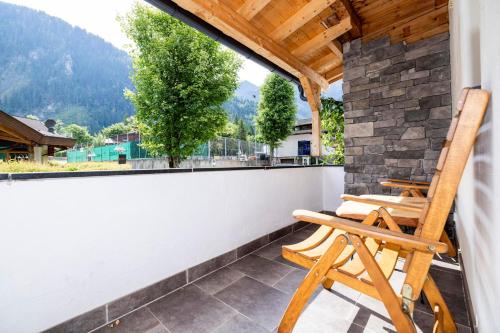 a rocking chair on a balcony with a view at Haus Wierer in Mayrhofen