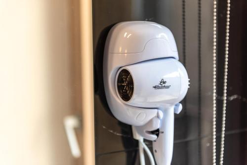 a white hair dryer hanging on a wall at Vico degli Orti in Mistretta