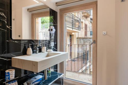 a bathroom with a white sink and a window at Vico degli Orti in Mistretta
