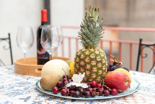 a plate of fruit on a table with a pineapple at Vico degli Orti in Mistretta