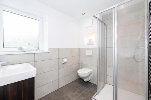 a bathroom with a toilet and a glass shower at Haus Wierer in Mayrhofen