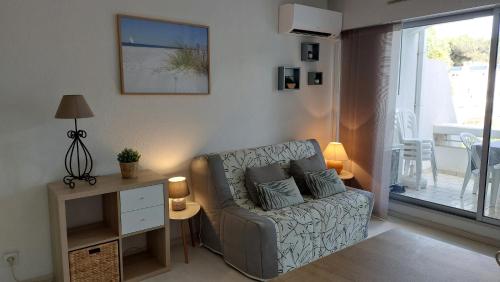 un salon avec un canapé et une table dans l'établissement Joli studio piscine Cat, à La Grande Motte