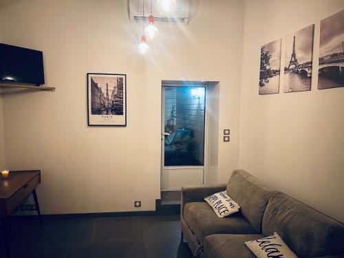 a living room with a couch and a television at Petite maison indépendante à 20min de Paris in Bonneuil-sur-Marne