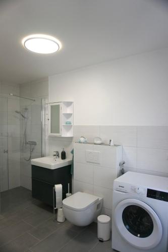 a bathroom with a toilet and a washing machine at Ferienwohnung Sonnenschein in Jüterbog