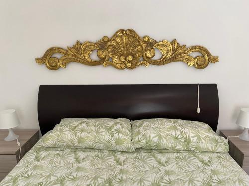 a bedroom with a bed with a gold headboard at Casa Mariuccia in Santa Margherita Ligure