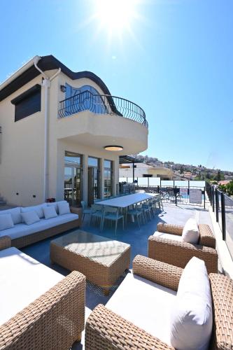 a patio with wicker chairs and tables on a building at Villa Blue Horizon in Tiberias