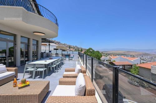 a balcony with tables and chairs on a building at Villa Blue Horizon in Tiberias