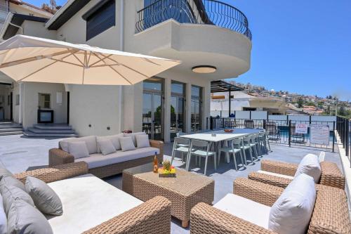 a patio with chairs and tables and an umbrella at Villa Blue Horizon in Tiberias