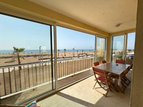 - une salle à manger avec une table et une vue sur la plage dans l'établissement Valras-Loc Panoramique Vue Mer au coeur de Valras, à Valras-Plage