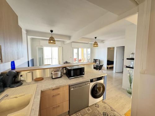 une cuisine avec un lave-linge et un sèche-linge sur un comptoir dans l'établissement Valras-Loc Panoramique Vue Mer au coeur de Valras, à Valras-Plage