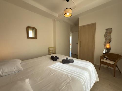 une chambre avec un lit blanc avec deux serviettes dessus dans l'établissement Valras-Loc Panoramique Vue Mer au coeur de Valras, à Valras-Plage