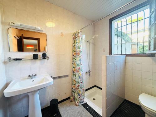 une salle de bain avec un lavabo et des toilettes et une fenêtre dans l'établissement Studio ouest à 300m des plages, à Mimizan