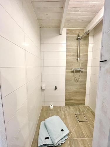 a bathroom with a shower with a towel on the floor at Charming 5 bed studio at Getterön in Varberg