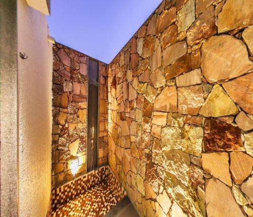 a room with a stone wall with a window at Araiya Gir,A Mavintara Resort in Chitrāwal